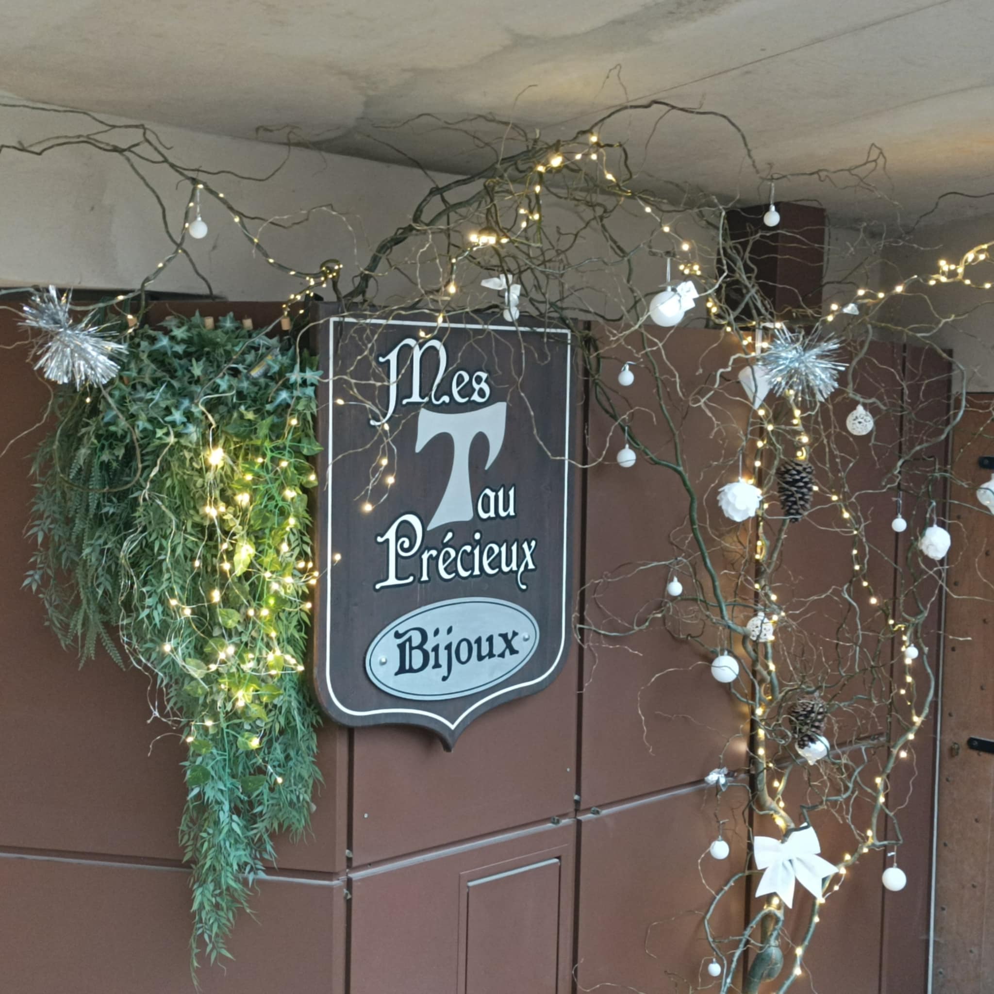 Enseigne Mes Tau Précieux et décor lumineux devant la boutique